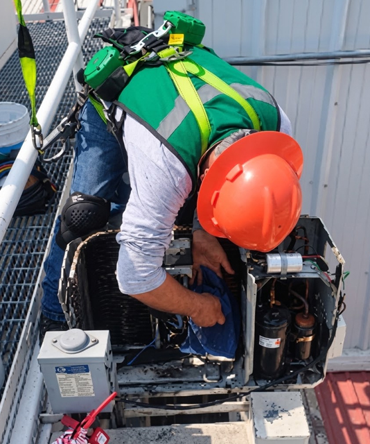 Técnico realizando mantenimiento preventivo a un equipo HVAC
